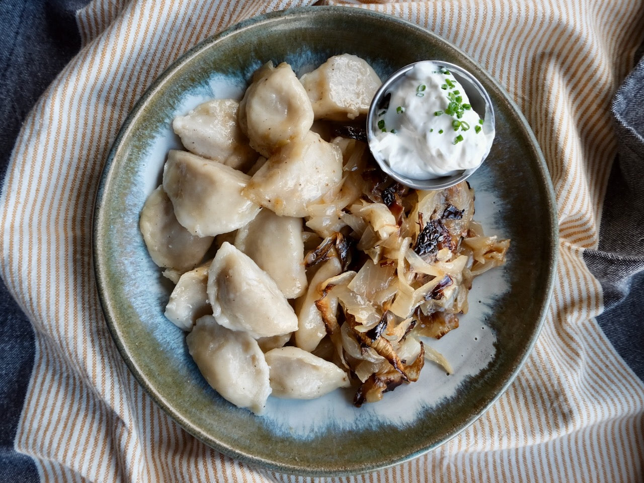 Piroguis de pommes de terre et cheddar au bacon ‘Berkshire’, oignons grillés et crème aigre